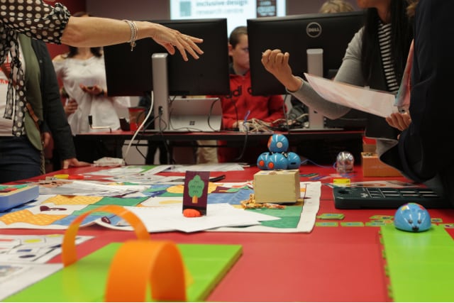 Two people trying the inclusive coding learning environment the IDRC has created, which involves robots, tactile boards, and cards.